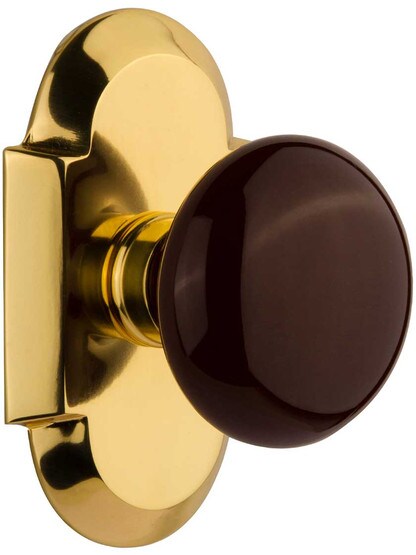 Arched Rosette Door Set with Brown Porcelain Knobs in Polished Brass.